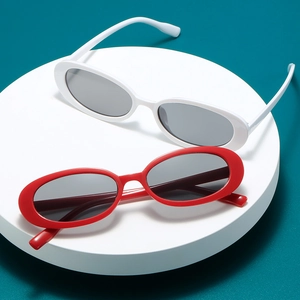 Vintage oval sunglasses in red and white frames on a minimalist podium set