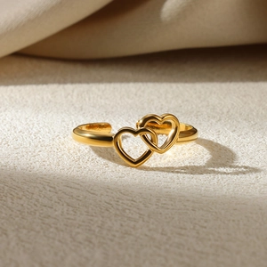 Macro shot of interlocking double heart adjustable ring with polished gold finish