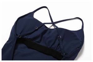 Detail of cross-back adjustable straps and elastic support band on navy yoga jumpsuit
