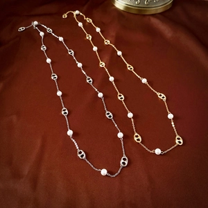 Macro shot of pig nose link necklace with white pearls on dark velvet background