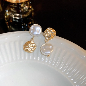 French style crumpled metal and pearl drop earrings shown on a ceramic dish