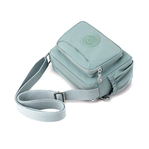 Water-resistant light blue nylon shoulder bag with front zipper pocket and side pockets