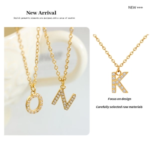 Close-up of gold-plated necklaces featuring crystal-encrusted O, N, and K letter pendants