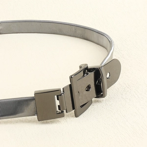 Detail of silver metallic spring waist belt featuring a sleek square buckle design