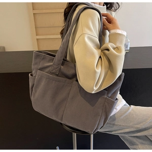 Vue détaillée du grand sac cabas en velours côtelé gris foncé avec des poches multiples