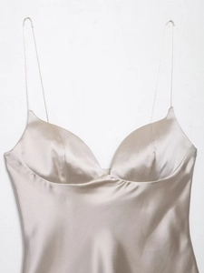 Detail of champagne satin camisole top showing V-neck cut and thin shoulder straps