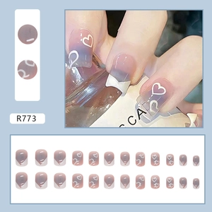 Detail of lavender gradient press-on nails with white heart patterns and French tips