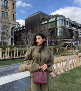 Detailed texture of olive green faux suede fabric on a stylish women's streetwear suit