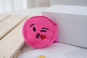 Detail view of pink plush coin purse featuring a winking face emoji with zipper closure