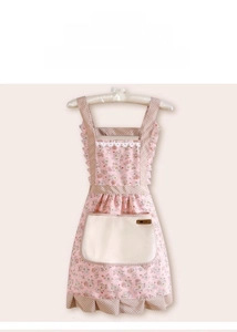 Detailed view of pink floral apron featuring lace trim, polka dot straps, and large pocket