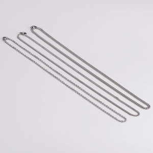 Three assorted silver Cuban link chains in different lengths on white background
