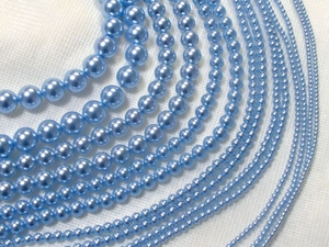 Macro shot of light blue round pearl beads strands in various sizes for DIY jewelry making