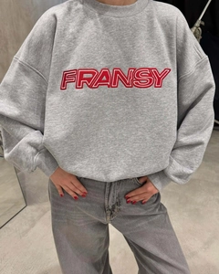 Détail du sweat gris à col rond avec broderie rouge et poignets en coton côtelé