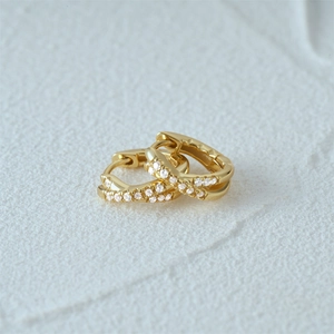 Macro shot of gold silver earrings with cross rows of sparkling white cubic zirconia