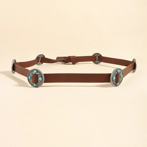 Detail of vintage brown leather belt with turquoise-studded silver round metal discs