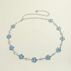 Detail shot of silver metal waist chain with blue flowers and sparkling crystal rhinestones