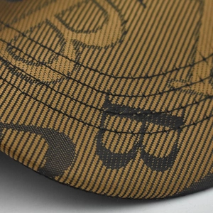 Macro shot of houndstooth weave fabric and FF letter embroidery detail on the baseball cap