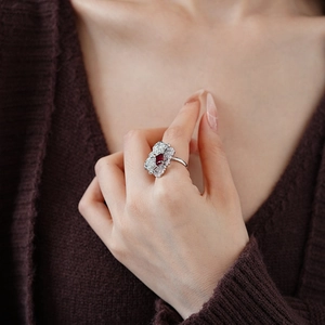 Close-up of silver flower ring with red rectangular stone and zircon pavé detailing