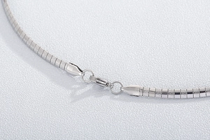 Macro view of matte textured links and polished clasp on silver titanium steel necklace