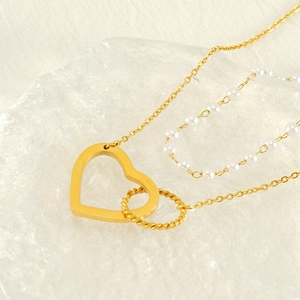 Gold double-layer pearl necklace with hollow heart and twisted ring pendant detail