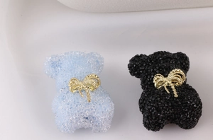 Detail of cute bear beads with sugar texture and golden bowknot for DIY jewelry crafts
