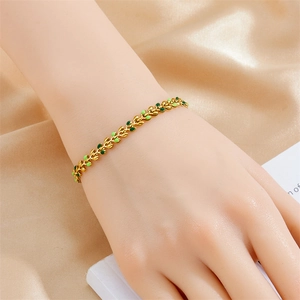 Gold plated leaf chain bracelet for women with green enamel details on champagne silk