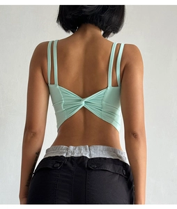 Detail of mint green sports bra featuring thin double straps and back twist knot design