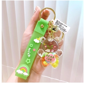 Nahaufnahme eines grünen Bärenanhängers aus Acryl mit Wish-Handschlaufe und Schlüsselring