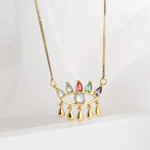 Détail du pendentif œil maléfique doré avec cristaux CZ colorés et pompons gouttes