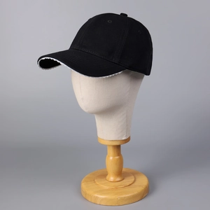 Gros plan d'une casquette de baseball noire avec bordure en dentelle blanche sur la visière