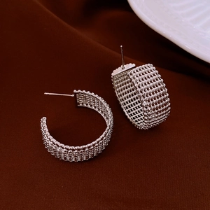 Detailed view of silver C-shaped hoop earrings with intricate metal mesh texture