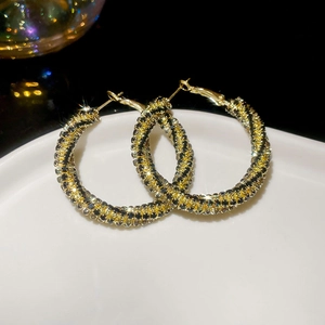 Detailed view of sparkling twisted hoop earrings with black and champagne rhinestones