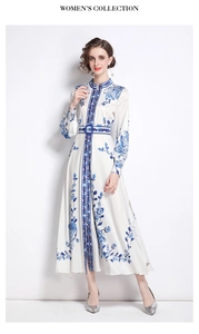 Detailed view of long-sleeved white dress with blue porcelain floral patterns and belt
