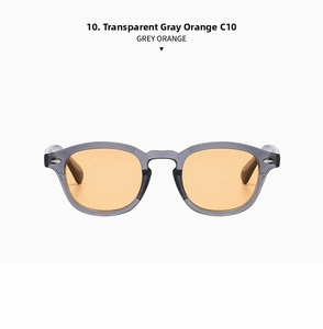 Detail view of transparent grey sunglasses frame with metal rivet accents and orange lenses