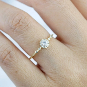 Macro shot of gold cluster ring with round diamonds on model's finger