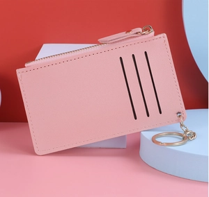 Close-up of pink leather card holder featuring three slots and golden zipper with keychain