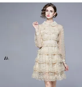 Détail de la robe à volants en dentelle florale abricot avec boutons rétro et col montant