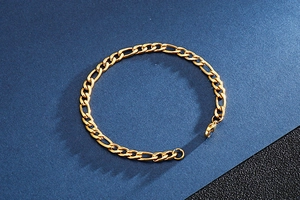 Macro view of golden Figaro style chain with classic 3:1 link structure and lobster clasp