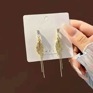 Detail of S925 silver needle tassel earrings with gold leaf and sparkling zircons