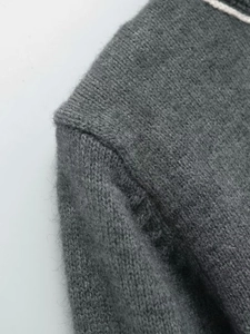 Detail of soft charcoal grey knit fabric showing high-quality shoulder stitching texture