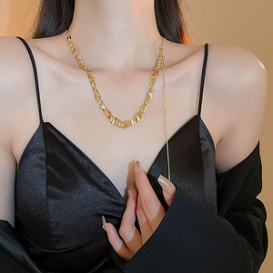 Golden wheat-shaped link necklace for women worn by a model in soft lighting
