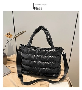 Detail of black quilted puffer tote bag with round handles and wide nylon shoulder strap