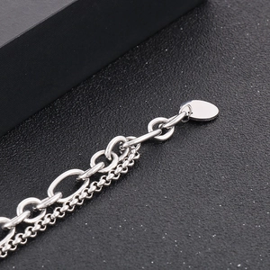 Macro view of silver double-layered hip-hop chain with an oval pendant on black background