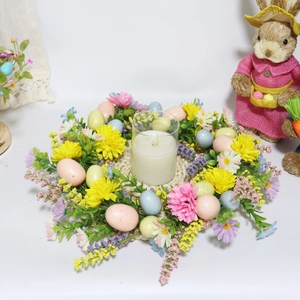 Easter wreath with pastel eggs, daisies, and a central glass candle holder on white