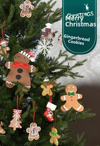 Close-up of decorative gingerbread man and Christmas tree ornaments on a green pine tree