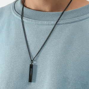 Close-up of minimalist black rectangle pillar pendant necklace on a male model wearing blue