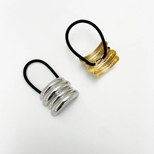 Close-up of gold and silver metallic textured hair ties with wavy spiral patterns