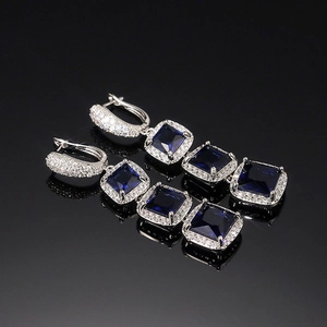 Detail of square-cut deep blue zircon drop earrings with silver metallic finish