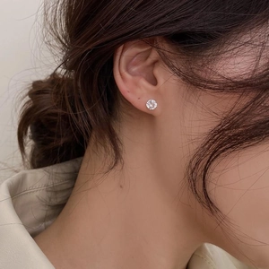 Gros plan de boucles d'oreilles minimalistes en argent S925 et zircon sur l'oreille femme