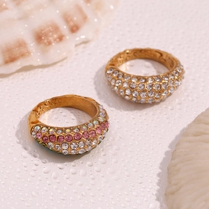 Detail of 18K gold plated stainless steel rings with full crystal pavé on marble base